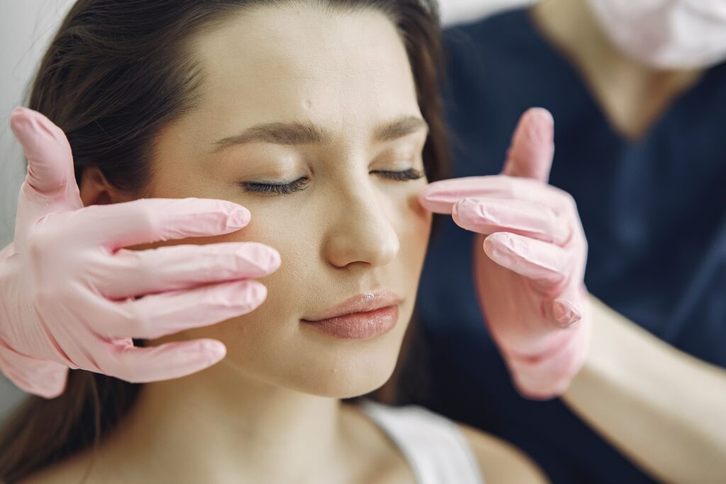 TESTIMONIOS Close-up of a woman with eyes closed receiving facial care in a beauty clinic indoors.